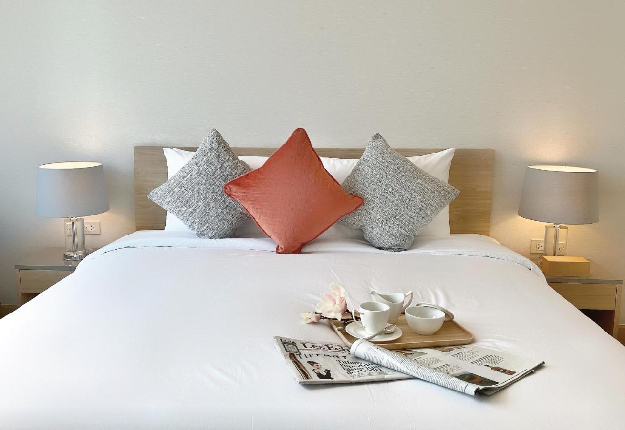 Oakwood Suites Bangkok Dış mekan fotoğraf A bed with cushions